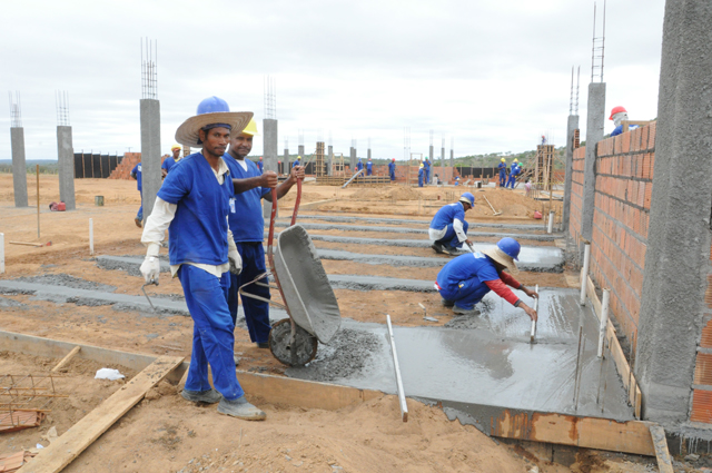 pedreiros cimentam piso onde serão as salas de aula